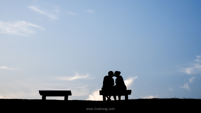 情侣在长椅上拥抱亲吻