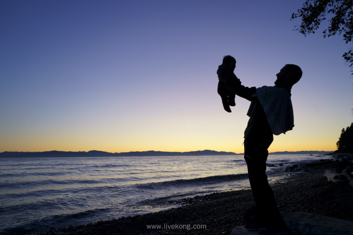 父亲抱着孩子在海边的剪影