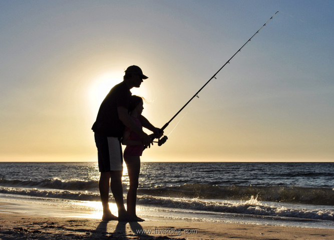 日落时分父子在海边钓鱼