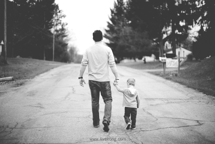 父亲牵着孩子的手散步