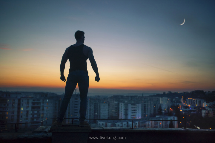 男人站在楼顶看城市夜景