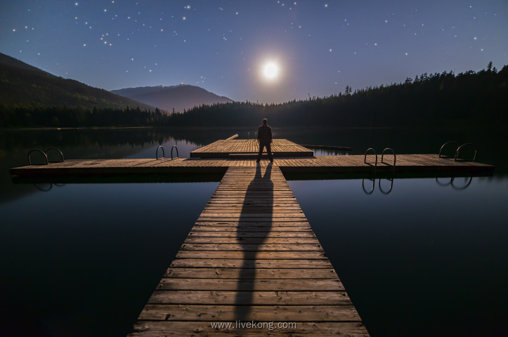 男人站在小桥上看月亮