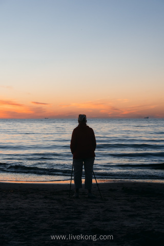 傍晚时分老人站在海边看大海风景