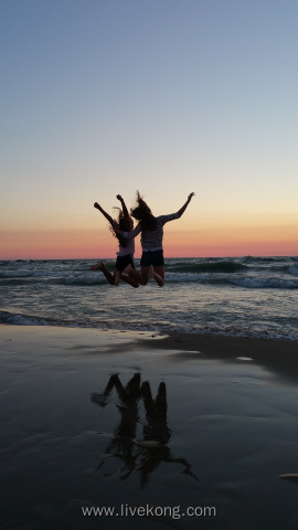 两个女孩儿在海边跳跃